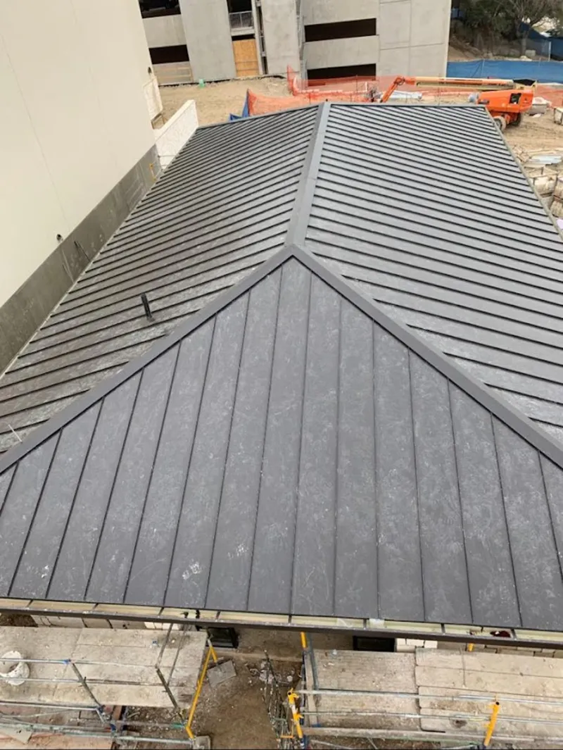 Commercial metal roof construction with crane equipment in Oakdale