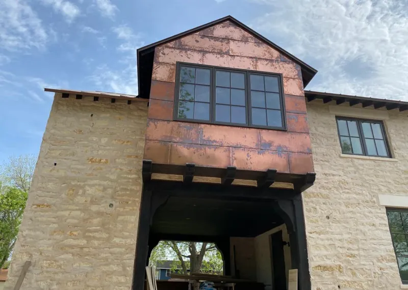 Copper metal panel facade on a stone building for Roof Repair in Oakdale